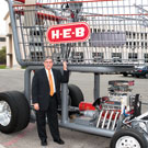 UTSA President Ricardo Romo with a large H-E-B shopping cart