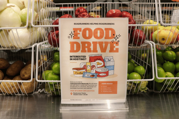 food drive sign in front of crates of fruits and vegetables