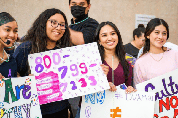 four female students holding posters at take back the night