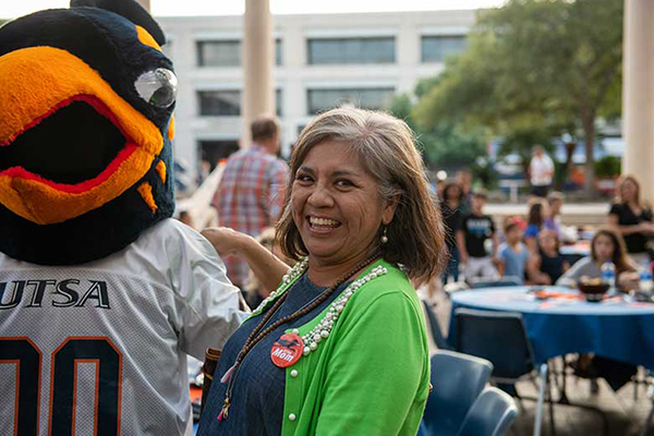 UTSA parent laughing with Rowdy mascot at Family Weekend Dinner