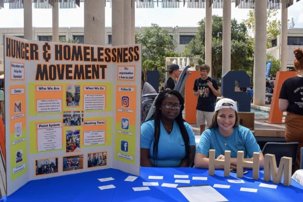 Students pose at their Volunteer Fair booth