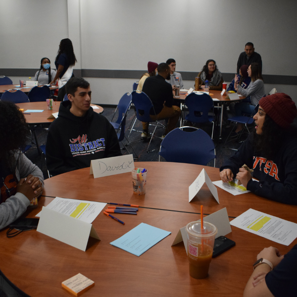 Students sitting a round tables talking
