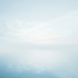 Calming, surreal blue sky over blue water.