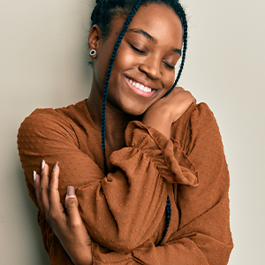 Person wrapping their arms around themselves and smiling.