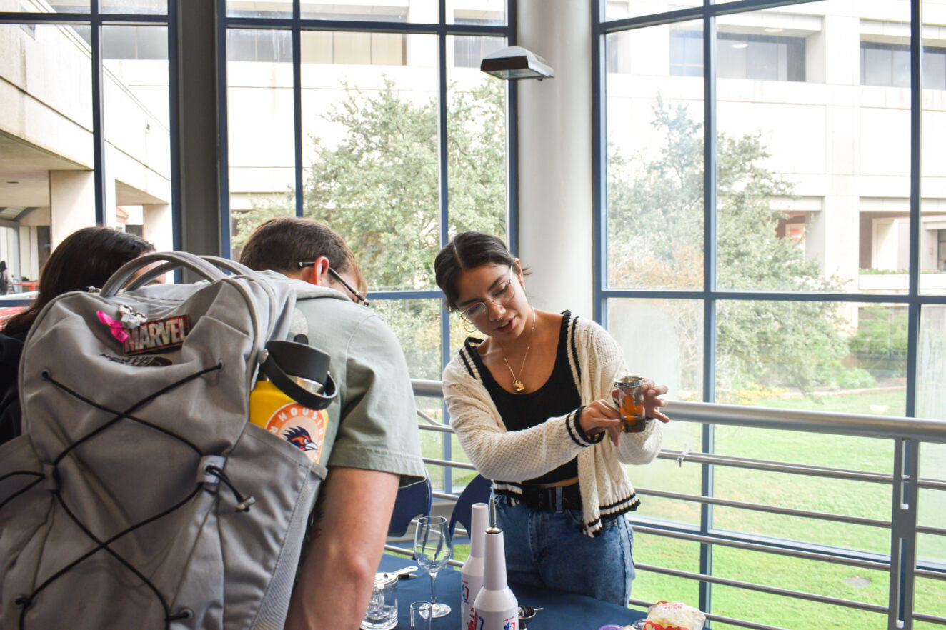 Students at a table, looking at a cup