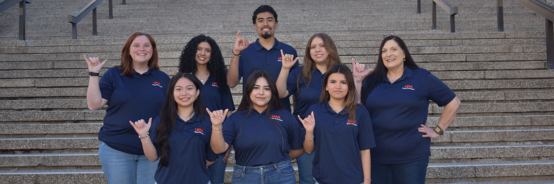 Bold Scholars Team on steps doing birds up hand sign